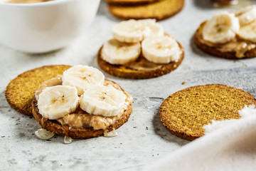Crispbread with peanut butter, banana and honey. Vegan food concept.