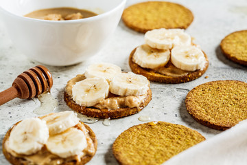 Crispbread with peanut butter, banana and honey. Vegan food concept.