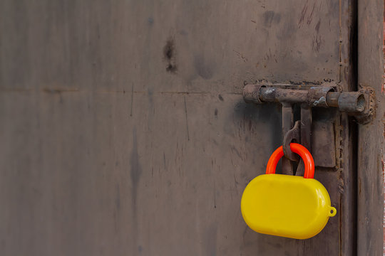 Colorful Toy Padlock Was Locked The Old Metal Door. Background For How To Protect Your Business And Network Or Stupid Password Concept. Selective Focus And Copy Space.