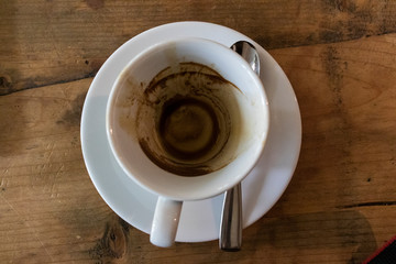 Empty white cup of Coffee on wooden table spoon on the side