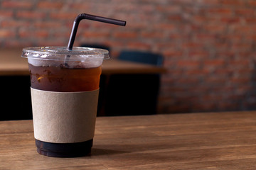 Close up of take away plastic cup of iced black coffee