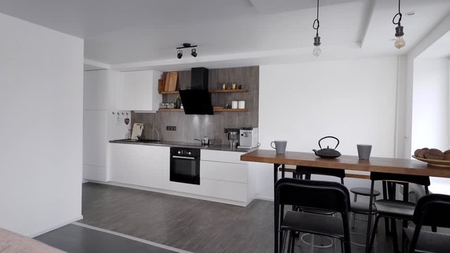 modern kitchen with dining zone and bar counter in apartment, moving view on interior
