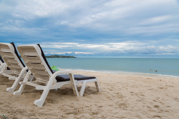 Rows of sun bed at sand beach for relaxing with tropical beach and sea