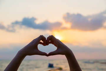 Hands make in heart form love with silhouette at sun set