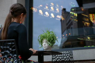 image from the back of a girl sitting at a cafe table
