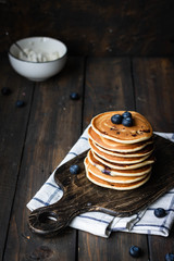 ricotta pancakes with blueberries on a dark wooden background