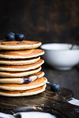 ricotta pancakes with blueberries on a dark wooden background