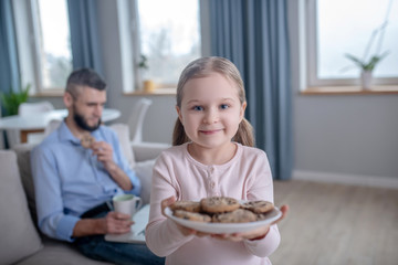 Obraz na płótnie Canvas Girl standing with a plate of cookies.