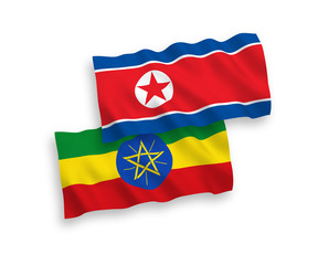 National vector fabric wave flags of North Korea and Ethiopia isolated on white background. 1 to 2 proportion.