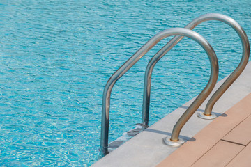 Stairs Ladder and handle down the swimming pool with blue water