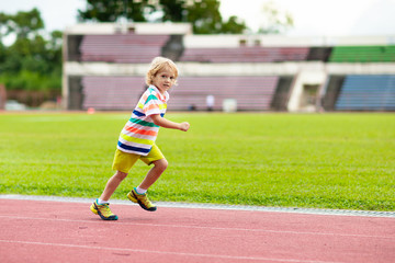 Child running in stadium. Kids run. Healthy sport.