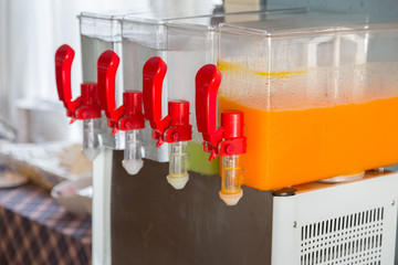 Orange juice and water in dispenser and glasses