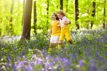 Kids in bluebell woods. Children play in park.