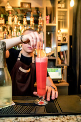 A bartender in a night club interferes with a cocktail