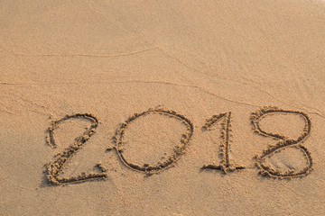 2018 message written in the sand at the beach