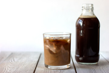  iced cold brew coffee in a bottle and in a glass. CBD concept. Modern fashionable drinks to go.