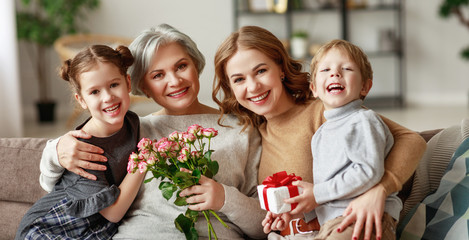 mother's day! three generations of  family grandchildren and children congratulate their mother and...