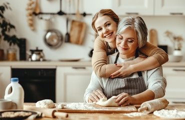 happy family grandmother  old mother mother-in-law and daughter-in-law daughter cook in kitchen, knead dough, bake cookies. - obrazy, fototapety, plakaty