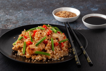 Tori chahan fried Japanese rice with vegetables and chicken in soy sauce in a black plate on a serving board