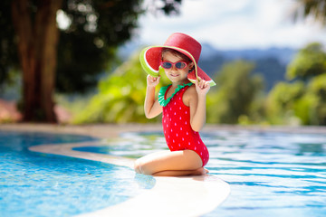 Child with hat in swimming pool. Tropical vacation