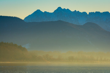 Fototapeta premium Berge am See im Nebel - Chiemsee am Abend