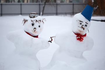 Snowman and Christmas decorations in the snowy day.