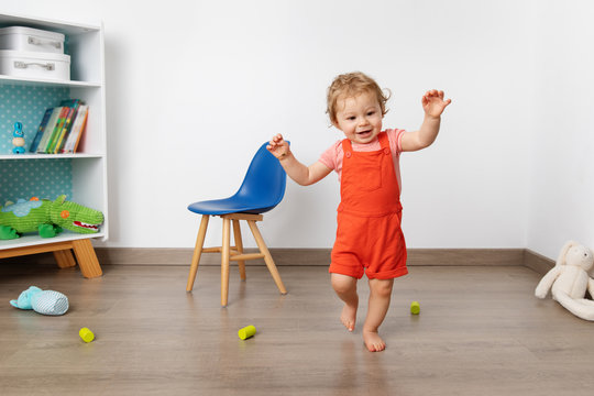 Baby making first steps in playroom