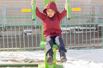 Boy on a public street simulator in winter. Children sports