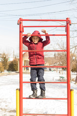 Boy on a public street simulator in winter. Children sports