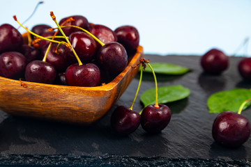 Ripe sweet cherry in a wooden bowl