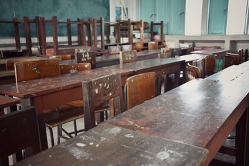 A dilapidated and dirty student desk and chair in classroom