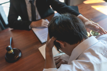 Lawyer working with client discussing contract papers with brass scale about legal legislation in...