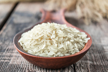 White rice with a wooden spoon on a stele. Jasmine rice for cooking.