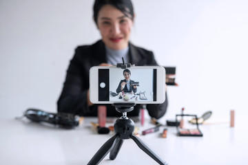 Business online on social media, Beautiful woman blogger is showing present tutorial beauty cosmetic product and broadcast live streaming video to social network while recording teaching online