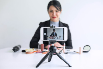 Business online on social media, Beautiful woman blogger is showing present tutorial beauty cosmetic product and broadcast live streaming video to social network while recording teaching online
