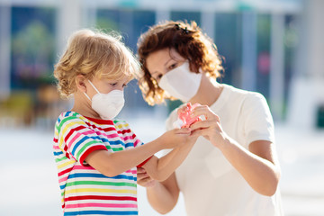 Mother and child with face mask and hand sanitizer