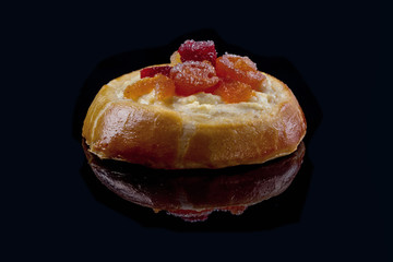 Tasty freshly baked muffin with marmalade on a black mirror surface. Close-up.