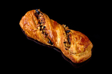 Puff pastry bun with cheese and vegetables. Black background. Close-up.