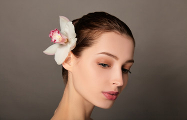 Fototapeta premium Health and beauty concept - relaxed woman with orhid flower.