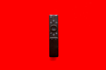 Television air recording concept. TV remote on red background top-down copy space