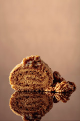 Walnut cake on a reflective background.