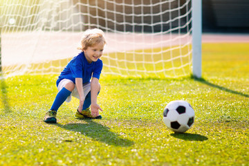Kids play football. Child at soccer field.