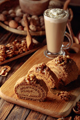 Walnut cake and coffee latte with cream on a wooden table.