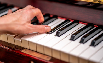 Fototapeta na wymiar Human hand playing the piano with selective focus