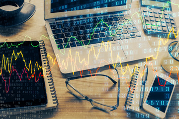 Double exposure of chart and financial info and work space with computer background. Concept of international online trading.