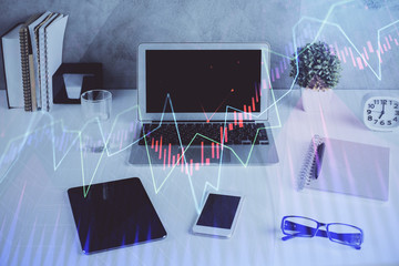 Stock market graph on background with desk and personal computer. Multi exposure. Concept of...