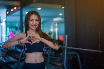 Obraz na płótnie Canvas Cute Asian girl is enamored at the gym and she is happy after her workout.