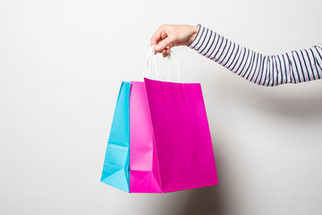 Female hand holds shopping bags on a white background. Concept shopping, discount, sale. Banner