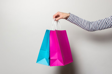 Female hand holds shopping bags on a white background. Concept shopping, discount, sale. Banner