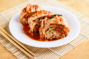Kimchi cabbage on white plate and chopsticks, Korean food